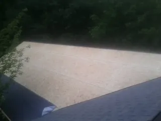 New OSB roof sheathing installed beside an existing shingle roof in Rock Cave