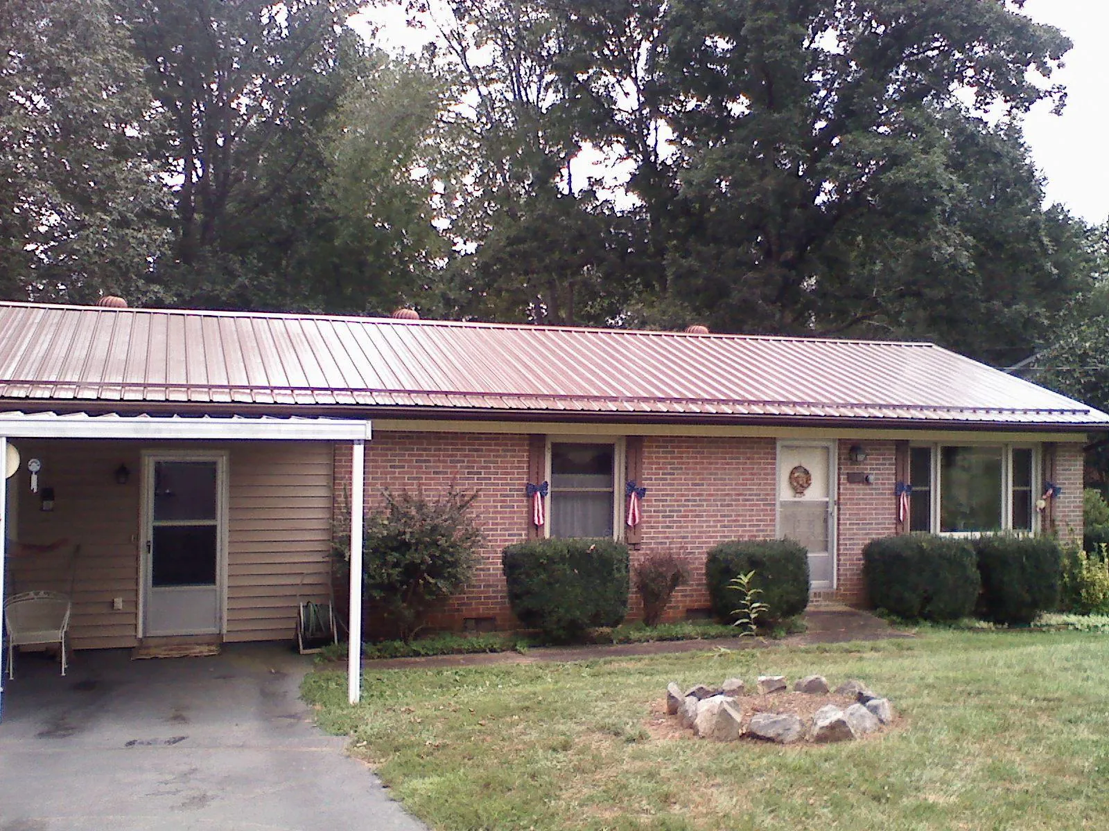 Bronze metal roof and carport on a brick ranch home — Roof Repair work by our crew in Rock Cave